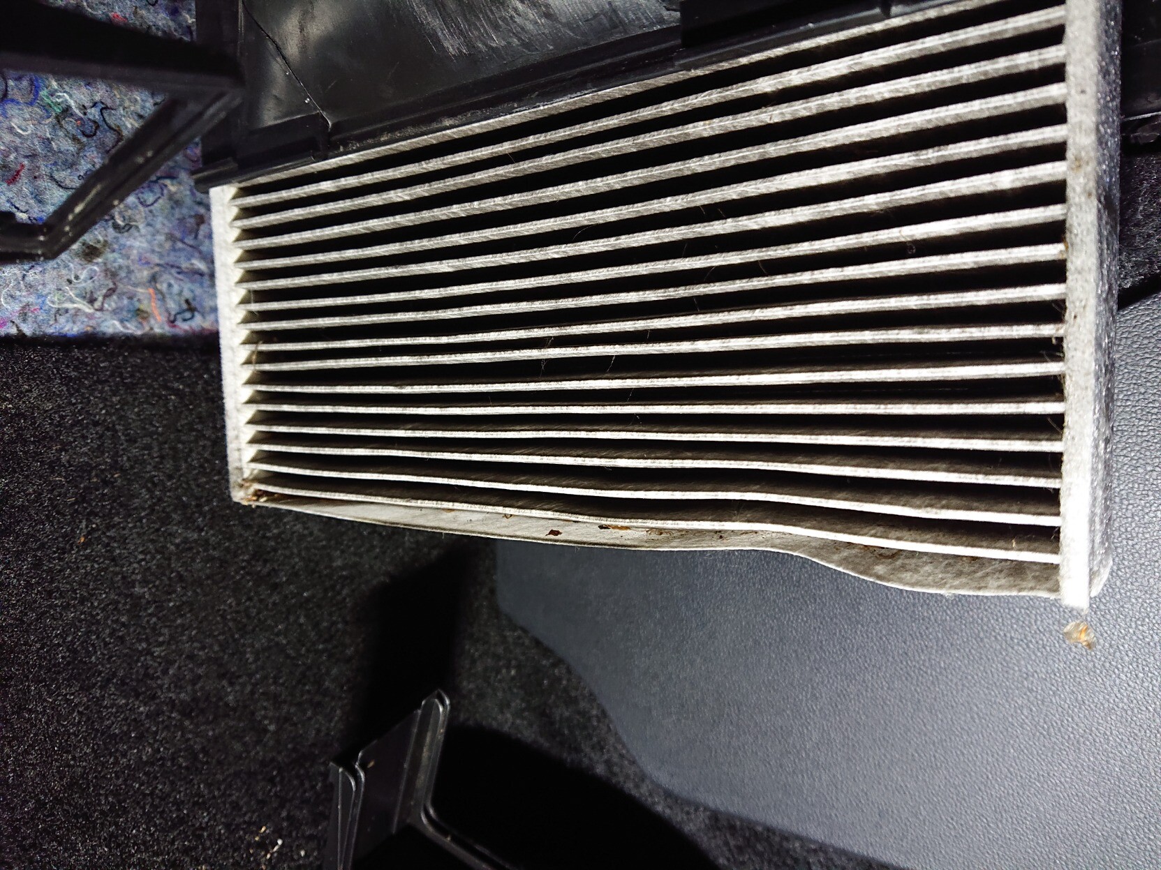 cabin air filter halfway removed from housing