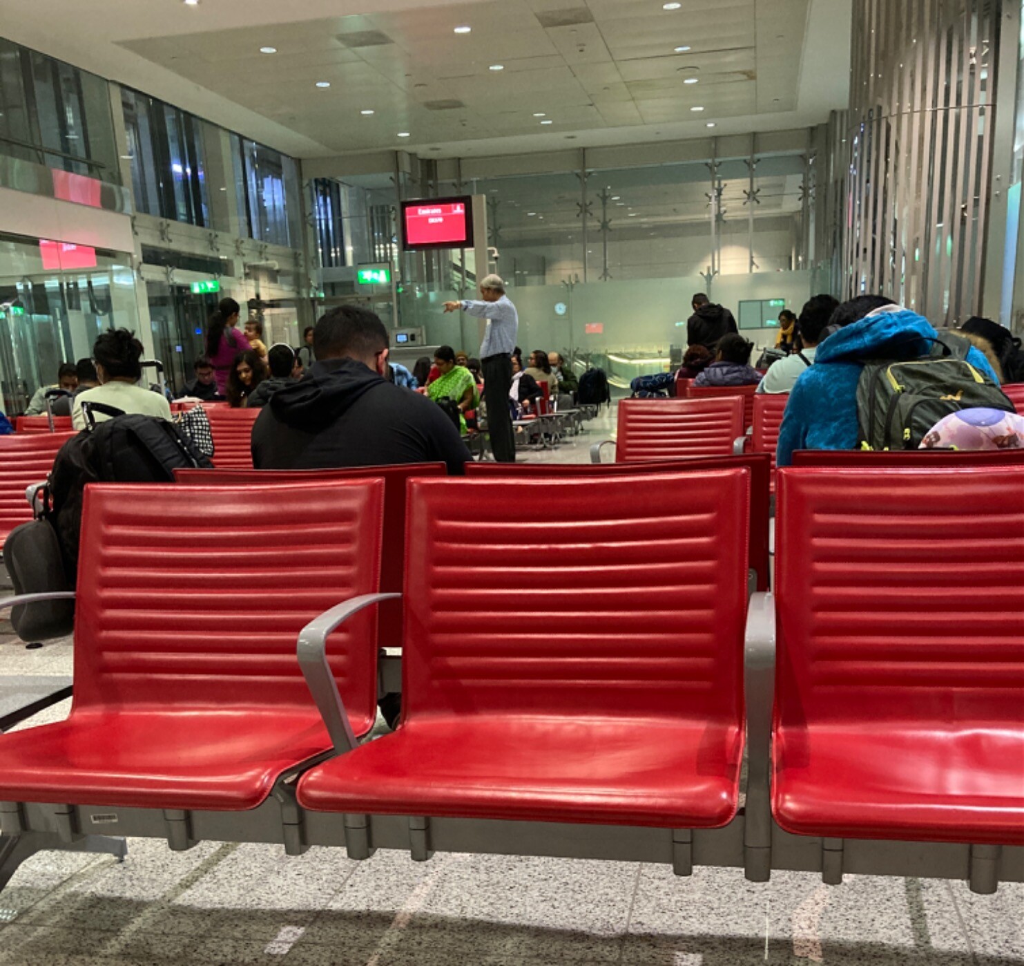Passengers waiting on red vinyl seats