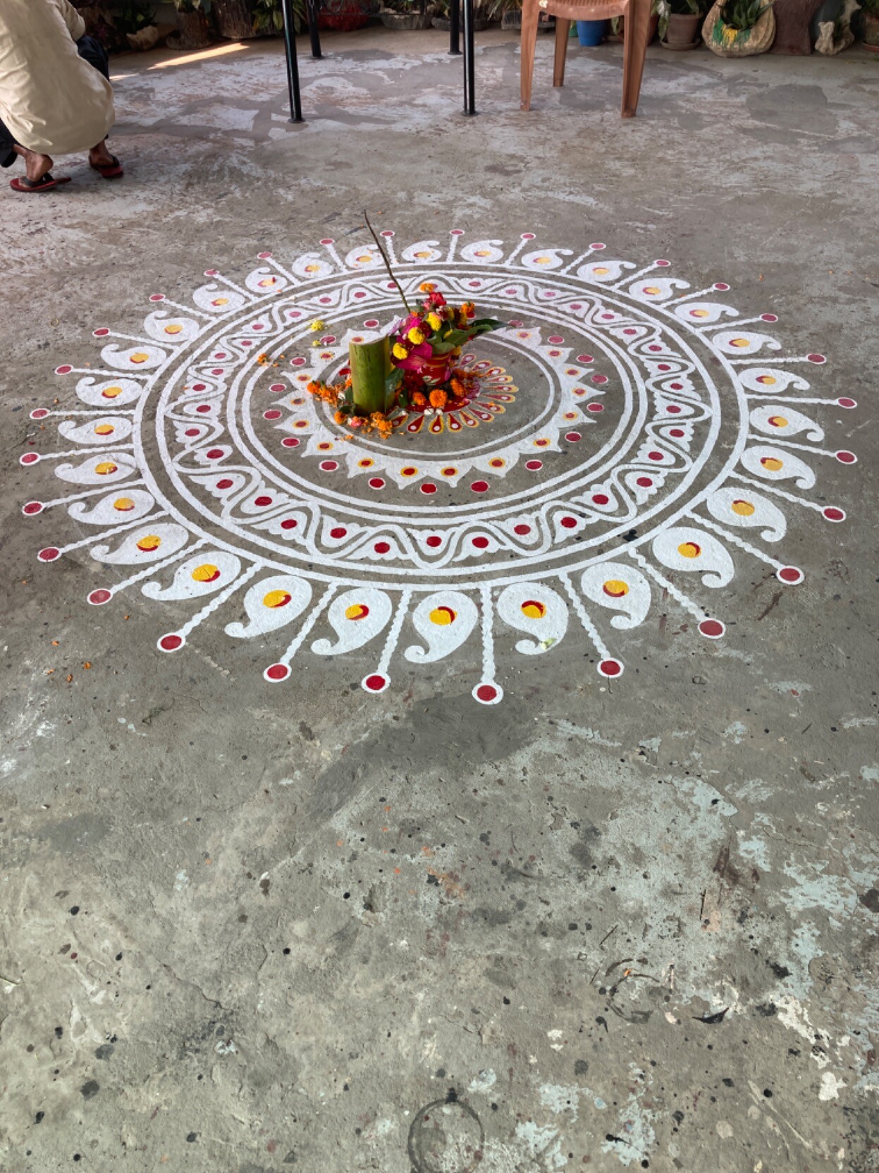 Circle of live flowers surrounded by circular abstract designs on roof landing