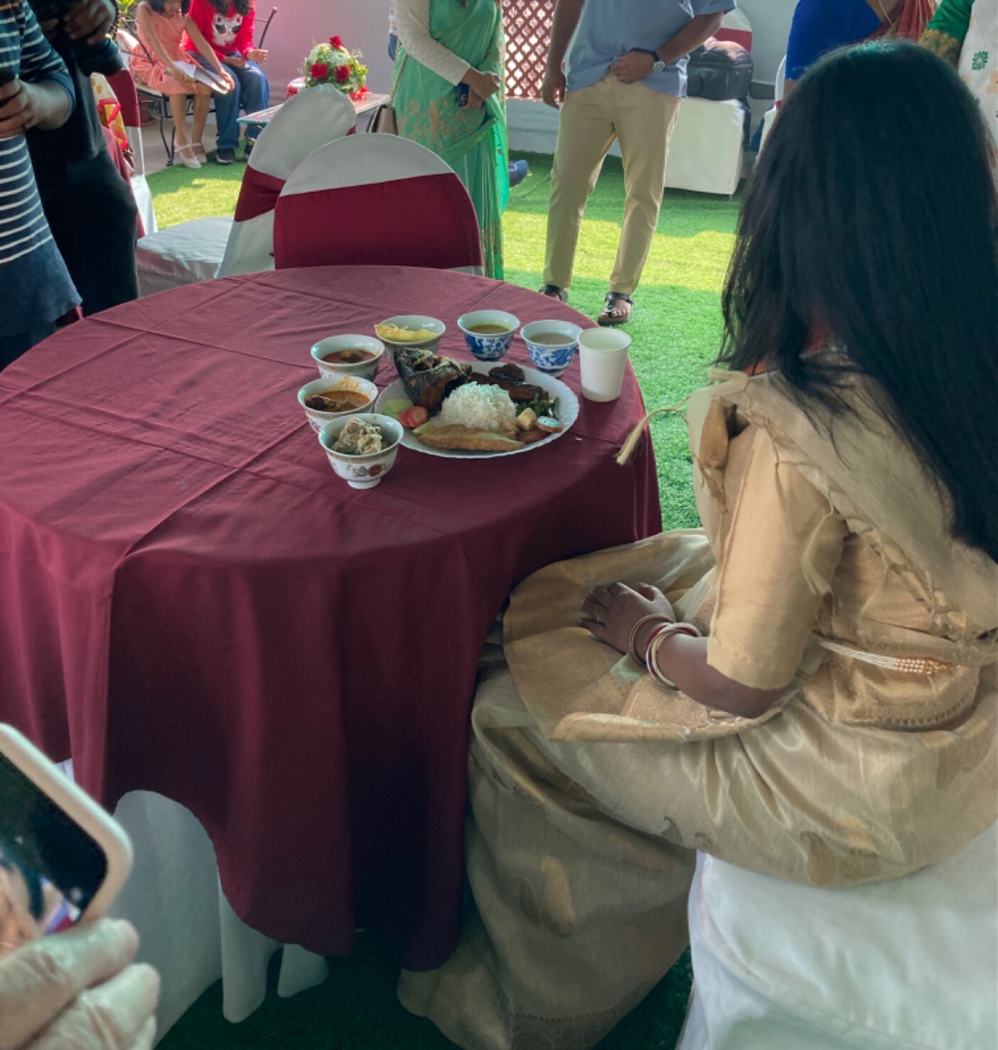 The bride sitting at a table laid with the symbolic foods.