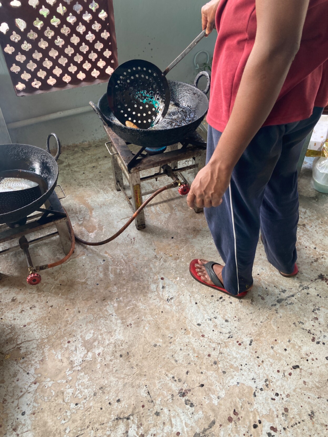 Cook wielding a scoop in a wok