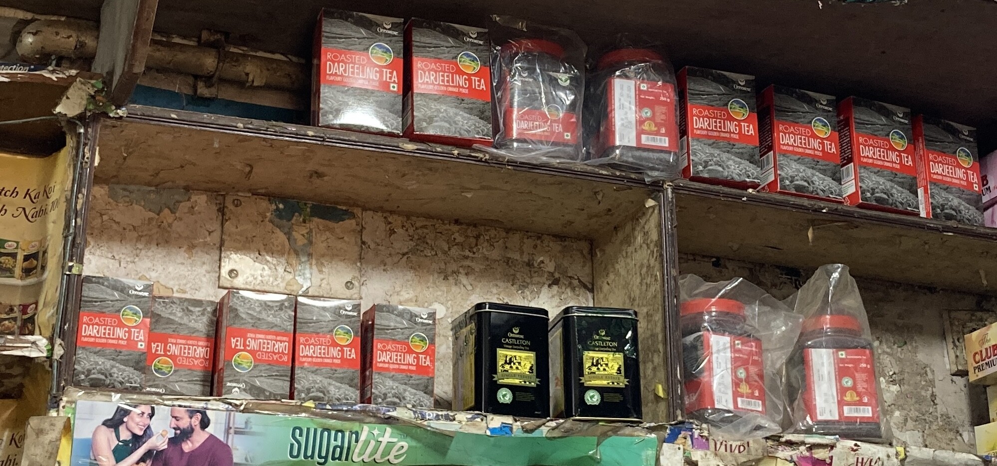 Two shelves of tea caddies plus some instant coffee hars