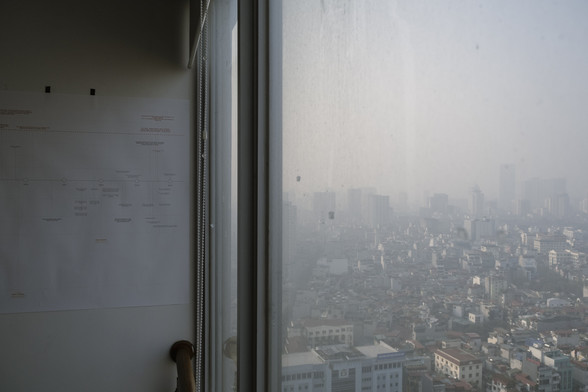 Left side: a timeline printed on a wall, left side: the view of the city. Fog, air pollution, actually. A visual reminder of what the facilities are capable of, semiconductor facilities