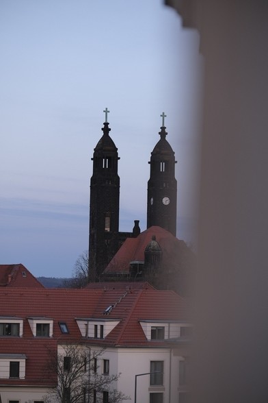 Shot of a church from the distance with red roofs in the front 