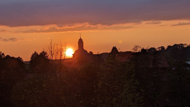 Sonnenuntergang mit Blick auf die Dorfkirche.
