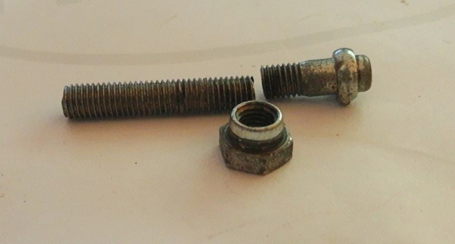 threaded pin broken in two parts and the appendant nut in front of it