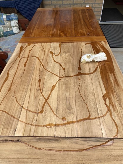 Der angeschliffene Holztisch wird geölt und eine Tischhälfte ist fertig, während auf dem Rest das verteilte Ök mit einem weichen Lappen verteilt werden soll