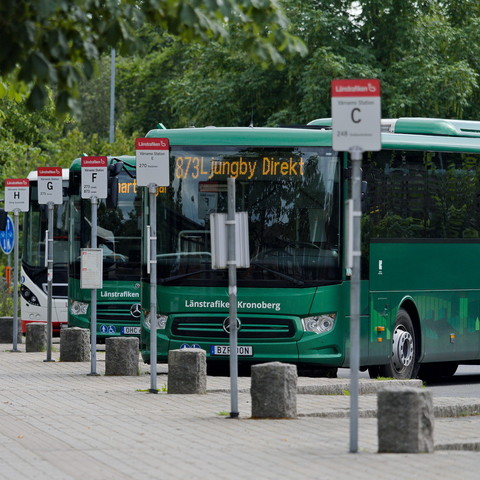 drei schwedische Busse in schrägen Haltebuchten hintereinander. Die vorderen beiden Busse sind grün. Auf dem ersten Bus steht 873 Ljungby Direkt