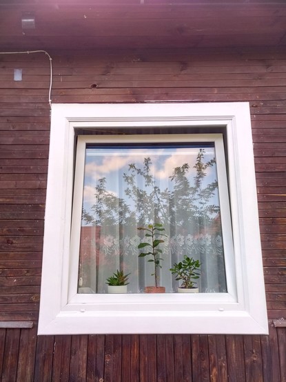 Same window, now with fresh white paint and masking tape removed. It matches the plastic window frame and looks neat and tidy.

Unfortunately the previous guy didn't use masking tape and his faded overpaint is still surrounding the edges.