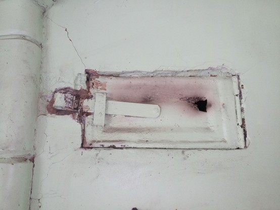 A rectangular inspection/cleaning hatch in a brick chimney. From memory, it is about 12-15cm tall and twice as wide. A little mortar around the latch has been chiseled off as some genius refurbisher had partially mortared over it.