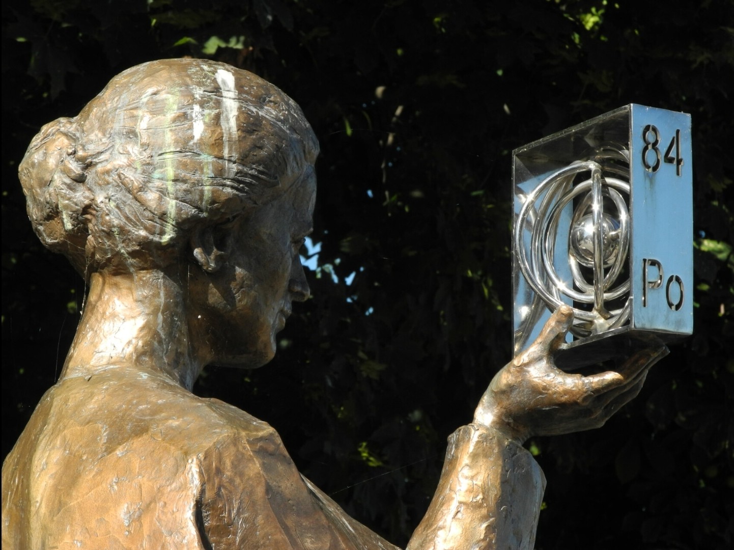 Eine Statue hält ein Atommodell hoch und schaut es an. Eine Statue hält ein Atommodell hoch und schaut es an.