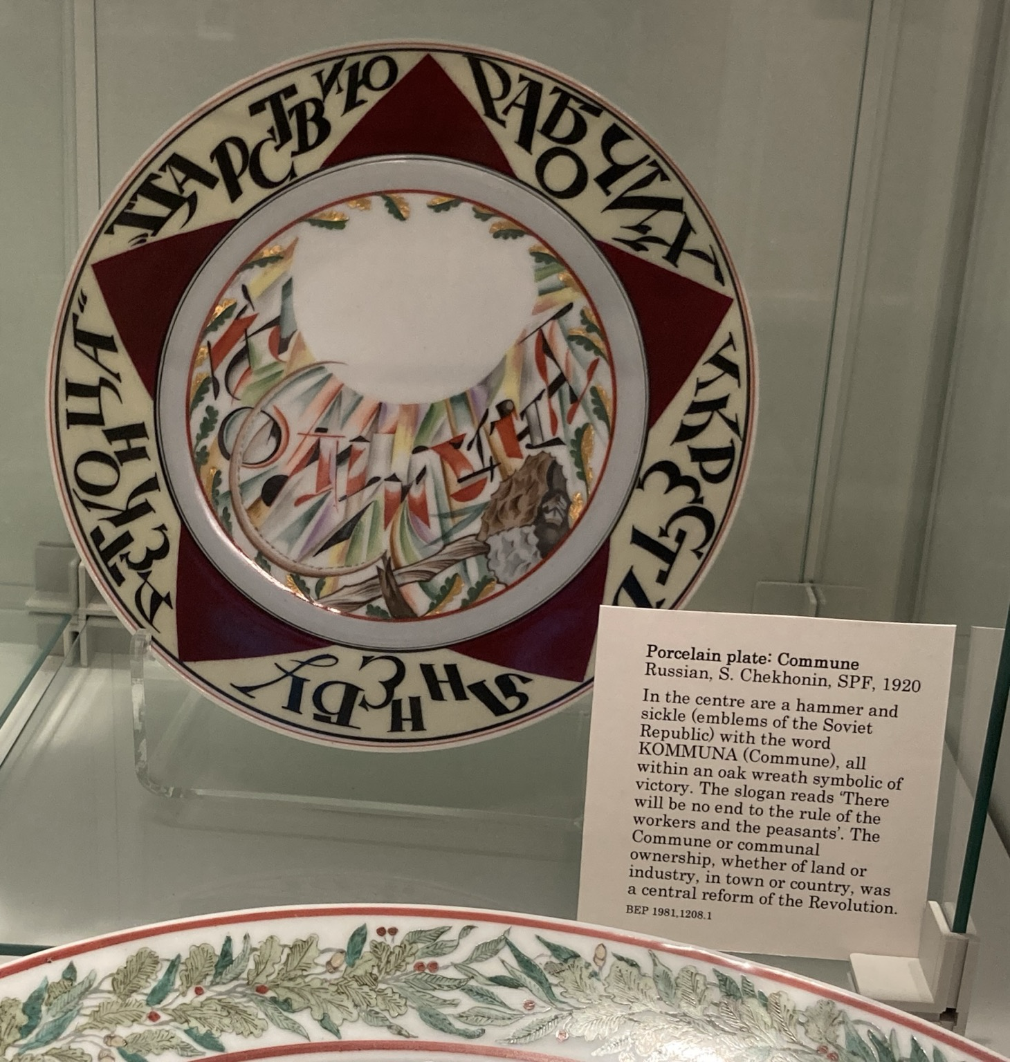 Caption: Russian, S. Chekhonin, SPF, 1920 In the centre are a hammer and sickle (emblems of the Soviet Republic with the word KOMMUNA (Commune), all within an oak wreath symbolic of victory. The slogan reads