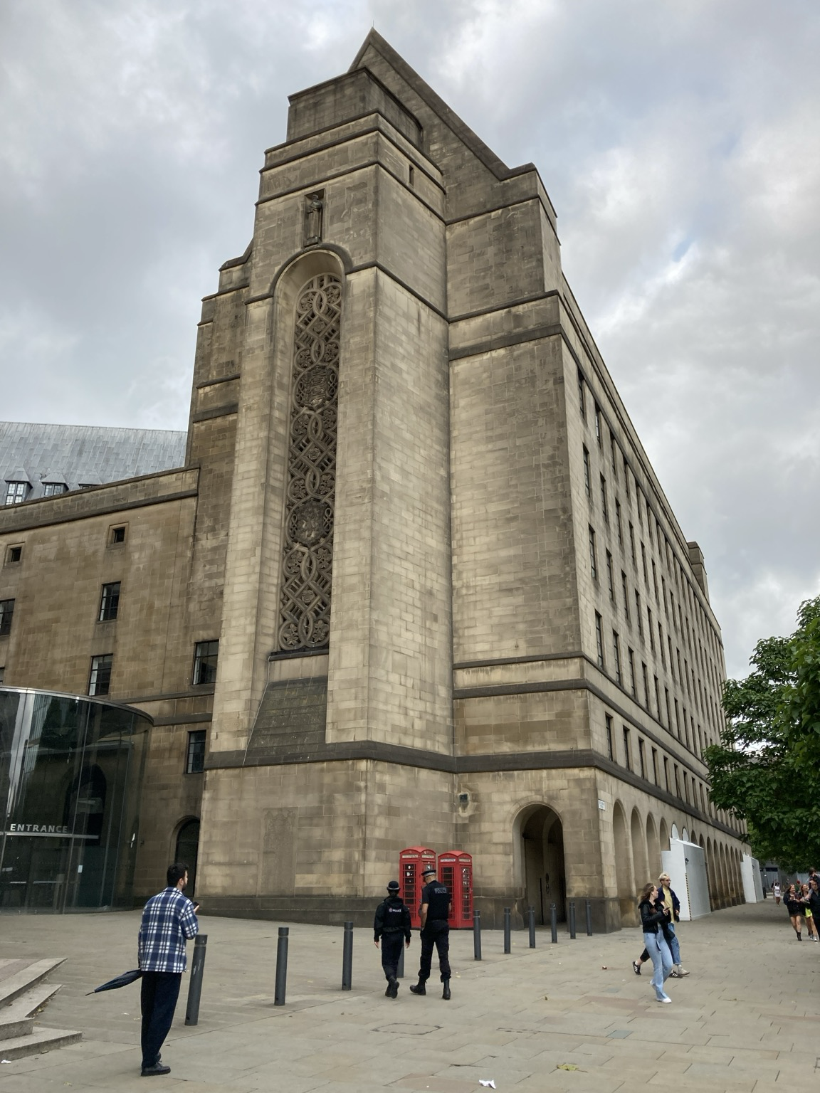 Tall, plain sandstone peaked-roof building unadorned except for a massive, multistory lacework window