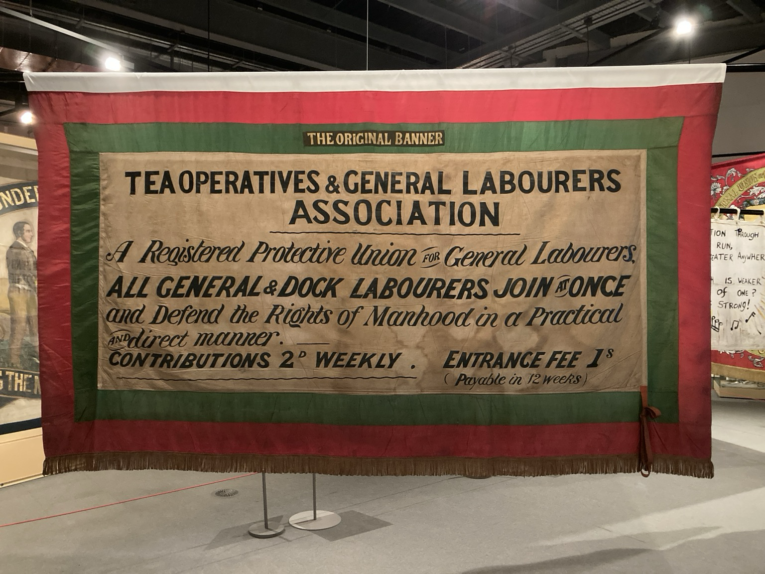 Framed in green and red: TEA OPERATIVES & GENERAL LABOURERS ASSOCIATION A Registered Protective Union fu General Labourers, ALL GENERAL& DOCK LABOURERS JOIN ONCE and Defend the Richts of Manhood in a Practical ANdirect manner. CONTRIBUTIONS 2° WEEKLY . ENTRANCE FEE IS