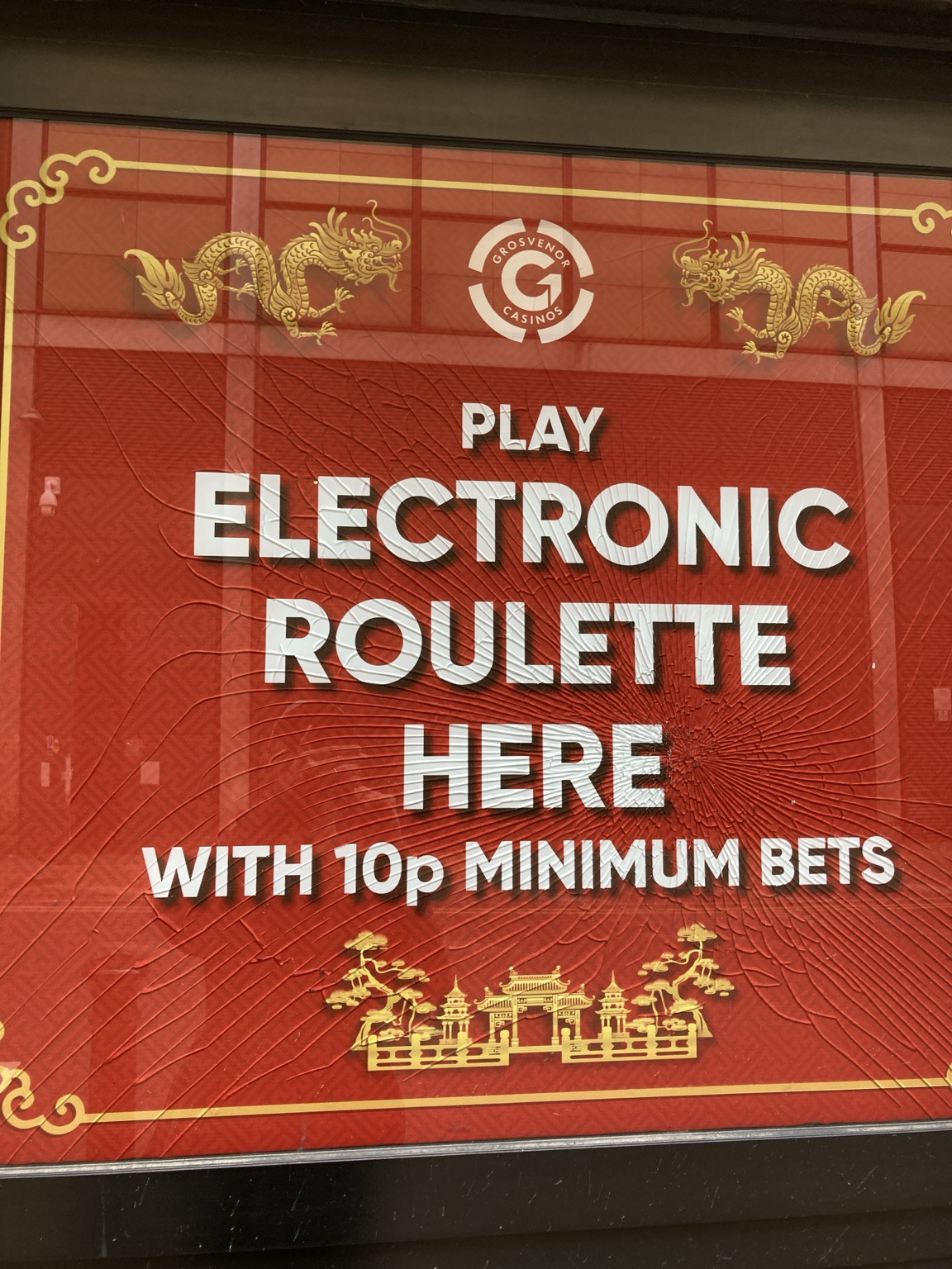 On a red background with stylized dragons, in white letters:?PLAY ELECTRONIC ROULETTE HERE WITH 10p MINIMUM BET