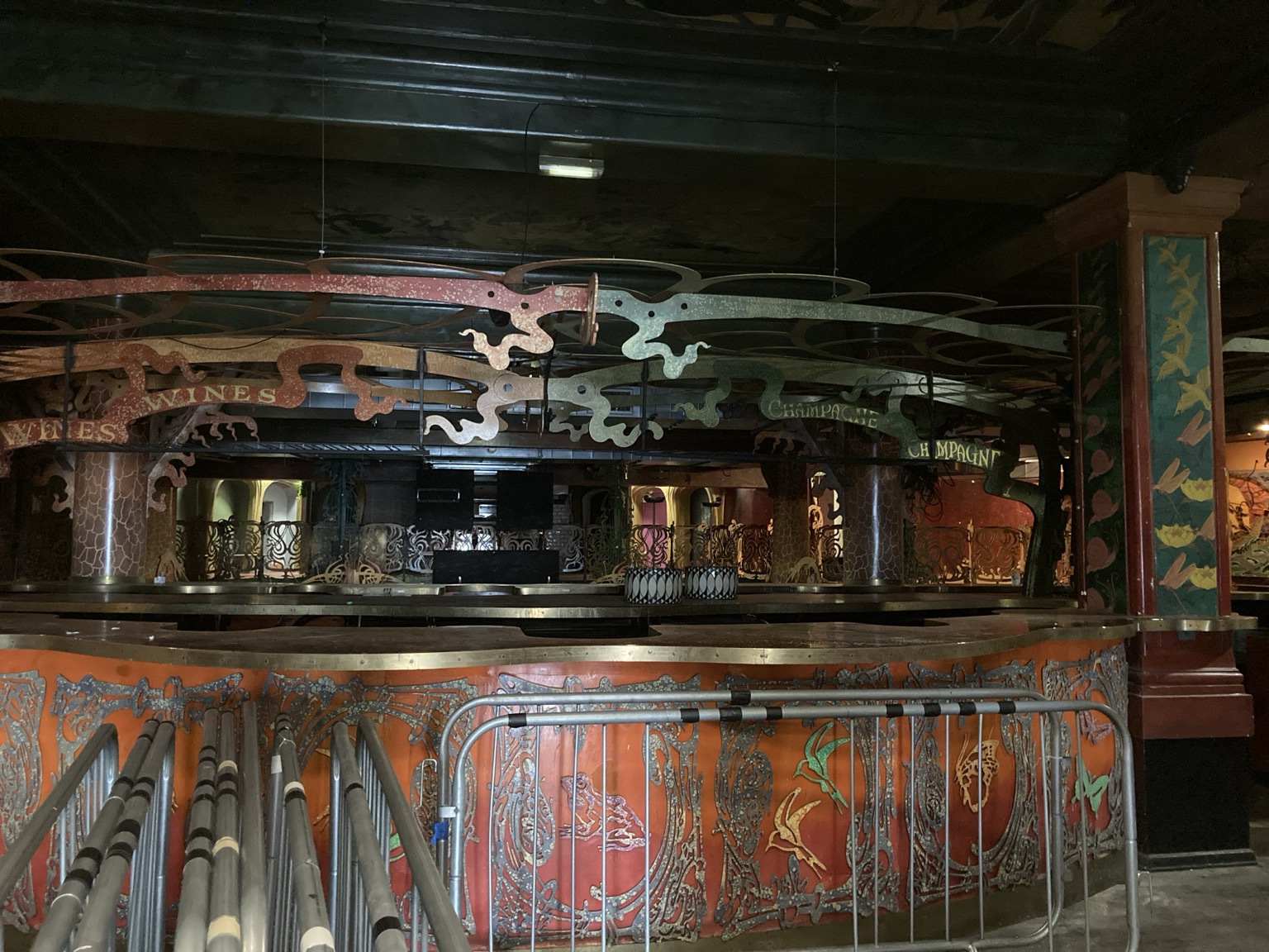 Long circular wooden bar crawling with sinuous metal decoration