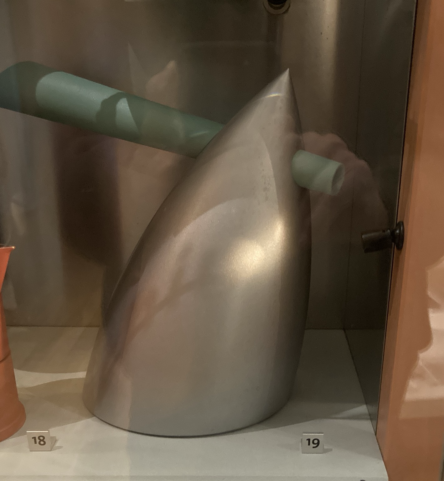 Kettle that looks like a metal powderhorn impaled by a thick green plastic tube