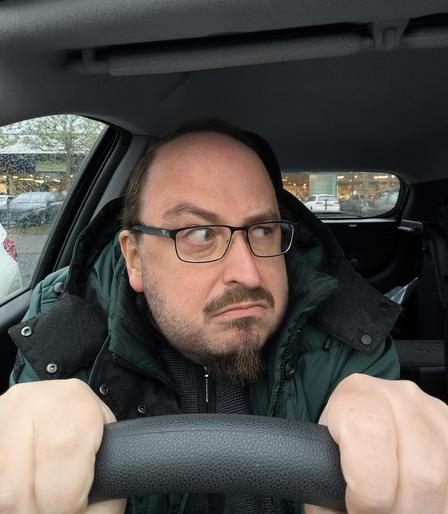 Selfie of me, sitting behind the wheel of my car, angrily glaring to the side, one eyebrow raised and ready for war.