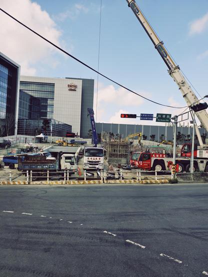The new fab 20 in Hsinchu, #Taiwan. Still under construction, you see a large road and a big grey box building with cars and construction in front 