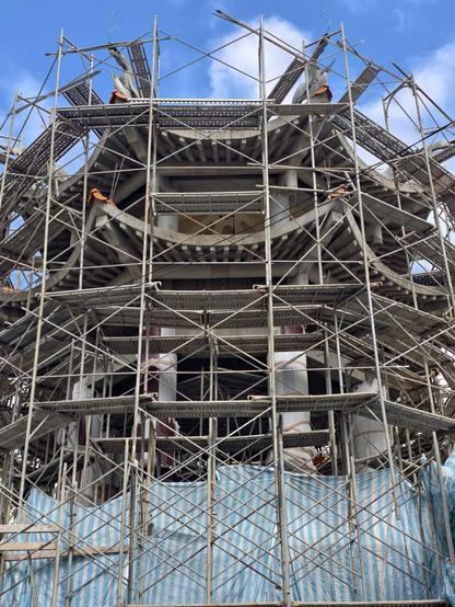 A temple under construction, a cement building mimicking wooden pagodas. 