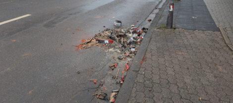 Müll der Silvesterfeuerwerksböllerei liegt am Straßenrand herum.