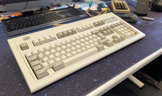 Eine Tastatur Modell M von IBM mit mechanischen Tasten liegt auf einem Schreibtisch.