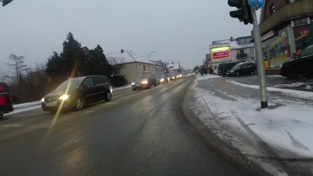 Aus der Sicht einer Lenkerkamera. Ein Fahrrad fährt von der Fahrbahn geradeaus auf einen benutzungspflichtigen Radweg, welcher schneefrei ist. Allerdings ist die Fahrbahn augenscheinlich von blankem Eis bedeckt. Da der Weg dort zur Fahrbahn in abschüssig angelegt ist, rutscht das Fahrrad weg und man hört den Fahrer Schmerzenslaute herauspressen.