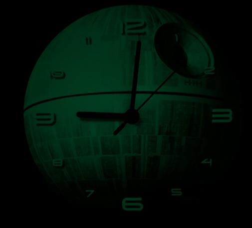 Eine selbstleuchtende, runde Analoguhr zeigt 9 Uhr an. Das Zifferblatt zeigt die Oberfläche des Todesstern.