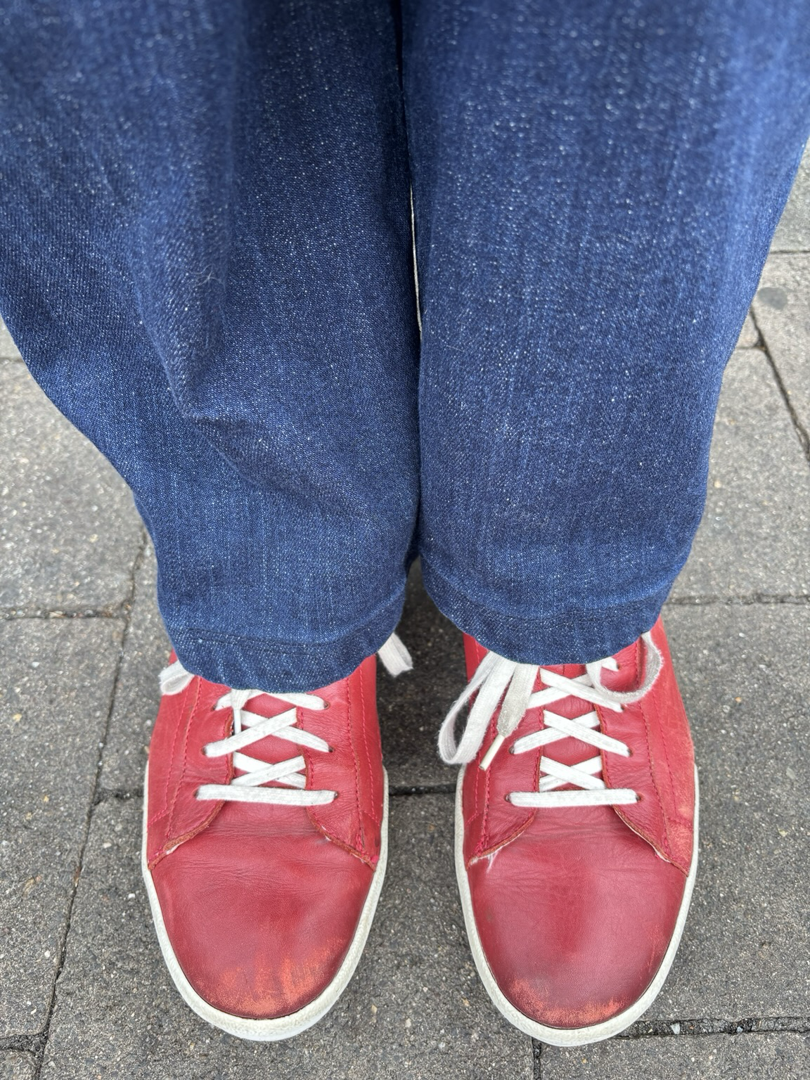 Dunkelblaue Jeans, rote Sneaket mit weiß