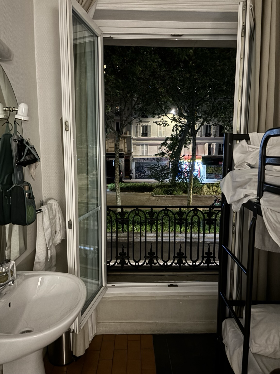 Hostelzimmer mit Etagenbett recht, Waschbecken links, Blick aus der Balkontür