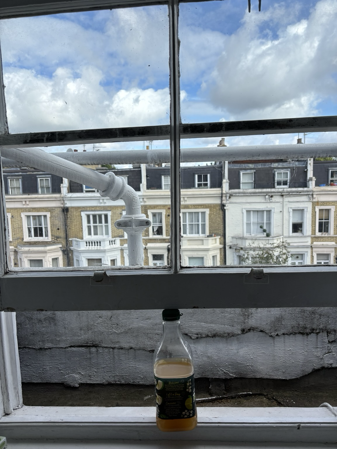 Fenster das von Apfelsaftflasche offen gehalten wird