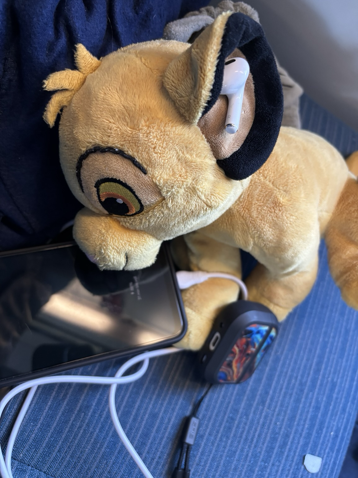 Simba-Stofftier mit Kopfhörern und Handy
