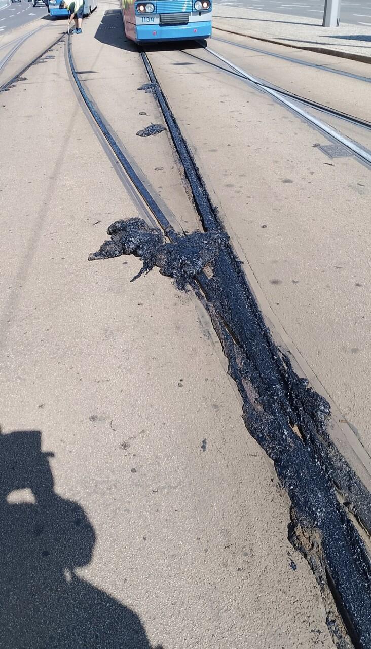 Bitumen ist unter den Schienen hervorgequollen und haben die Schienenspur komplett vollgeschlämmt. Es ist klar, dass hier keine Tram durchkommt.