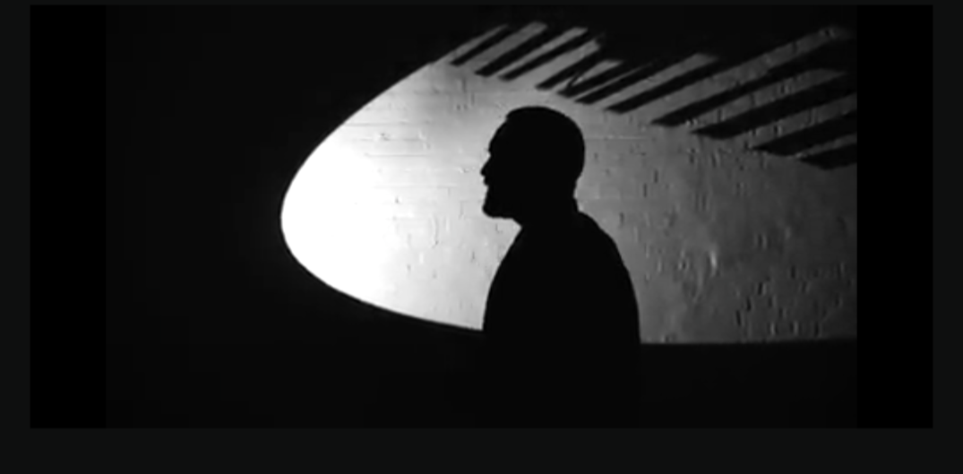 Danger Dan als Schatten an der Wand, beleuchtet von einem Spotlight. Aus dem Video zum Lied "Keine Angst"