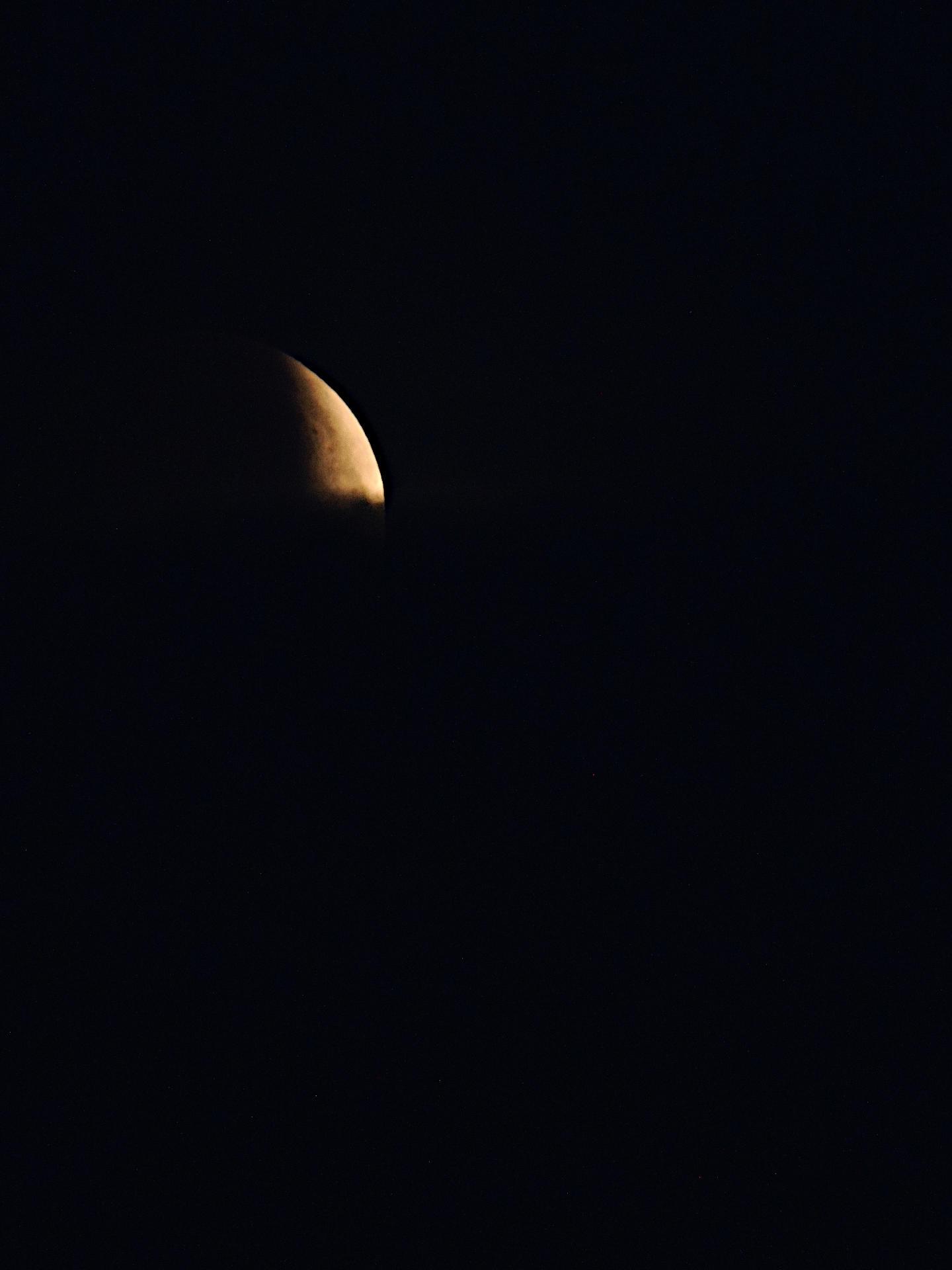 Der Mond während der partiellen Mondfinsternis am 28.08.2026 in Deutschland. Der untere Teil wird zusätzlich durch Wolken verdeckt, wodurch nur noch weniger als eine Ecke zu sehen ist.