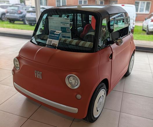 Ein orangenes Leichtkraftfahrzeug der Marke Fiat. Ein Topolino.